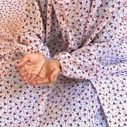 A woman using a breathable soft swiss lawn Namaz Chadar with Sleeves, performing salah By Clothifydotpk