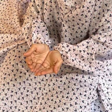 A woman using a breathable soft swiss lawn Namaz Chadar with Sleeves, performing salah By Clothifydotpk