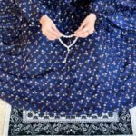 A woman using a breathable soft swiss lawn Printed Namaz Chadar with Sleeves, performing salah By Clothifydotpk