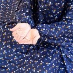 A woman using a breathable soft swiss lawn Printed Namaz Chadar with Sleeves, performing salah By Clothifydotpk