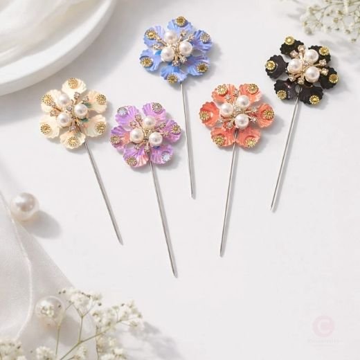 A close-up of a rhinestones and pearls brooch pins.