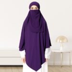 A woman wearing a long, single layer khimar that drapes over the head, and shoulders, falling to about waist length.