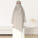 A woman wearing a long, single layer khimar that drapes over the head, and shoulders, falling to about waist length.