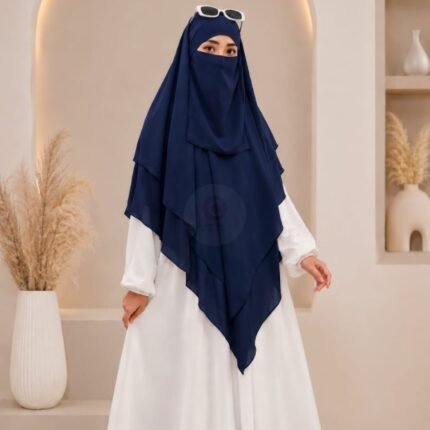 A woman wearing a three layer khimar, with the first layer covering her head and draping down over her chest, and two additional sheer or lightweight layers cascading underneath. BY CLOTHIFYDOTPK