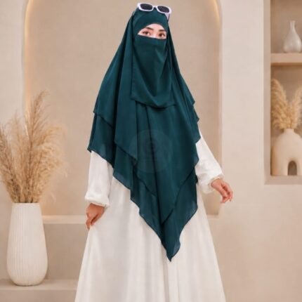 A woman wearing a three layer khimar hijab, with the first layer covering her head and draping down over her chest, and two additional sheer or lightweight layers cascading underneath. BY CLOTHIFYDOTPK
