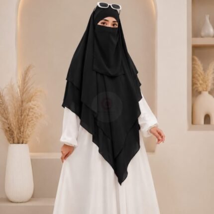 A woman wearing a three layer khimar, with the first layer covering her head and draping down over her chest, and two additional sheer or lightweight layers cascading underneath. BY CLOTHIFYDOTPK