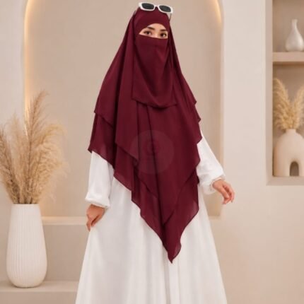 A woman wearing a three layer khimar, with the first layer covering her head and draping down over her chest, and two additional sheer or lightweight layers cascading underneath. BY CLOTHIFYDOTPK
