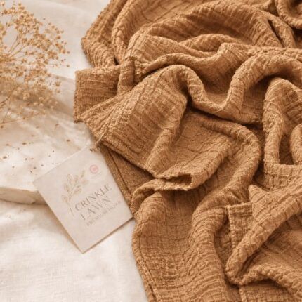 Close-up of amber crinkle lawn hijab fabric showing fine permanent pleats and lightweight weave. BY CLOTHIFYDOTPK