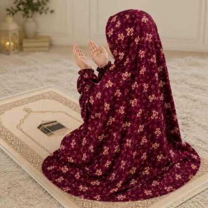 Young girl wearing a floral printed namaz chadar while praying on a mat. BY CLOTHIFYDOTPK