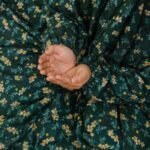 Young girl wearing a floral printed namaz chadar while praying on a mat. BY CLOTHIFYDOTPK