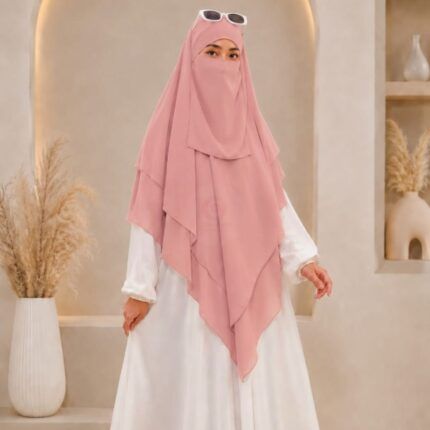 A woman wearing a three layer khimar with niqab , the first layer covering her head and draping down over her chest, and two additional sheer or lightweight layers cascading underneath. BY CLOTHIFYDOTPK