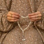 Woman wearing full length printed arabic namaz chadar holding prayer beads. BY CLOTHIFYDOTPK