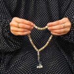 Woman wearing full length printed arabic namaz chadar holding prayer beads. BY CLOTHIFYDOTPK