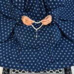 A woman performing Salah comfortably in a breathable, soft Swiss lawn Namaz Chadar with sleeves- available at CLOTHIFYDOTPK