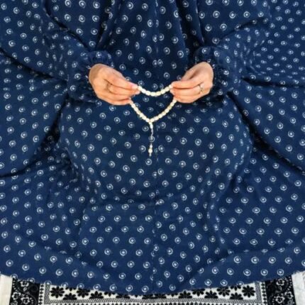 A woman performing Salah comfortably in a breathable, soft Swiss lawn Namaz Chadar with sleeves- available at CLOTHIFYDOTPK