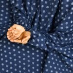 A woman performing Salah comfortably in a breathable, soft Swiss lawn Namaz Chadar with sleeves- available at CLOTHIFYDOTPK