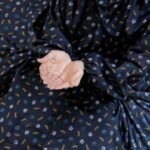 A woman wearing breathable soft swiss lawn modest coverage Namaz Chadar with sleeves, performing salah. By Clothifydotpk