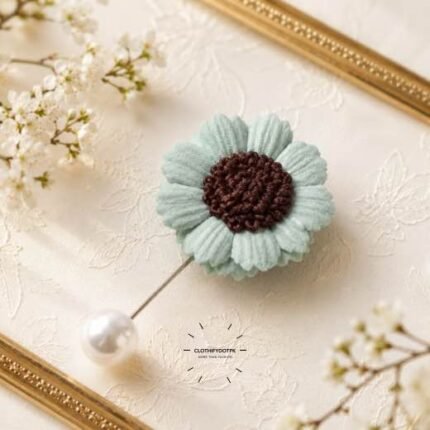 Hand-stitched flower shape brooch with petals and a pearl pin clasp.