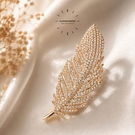A close-up of a modern, sophisticated brooch featuring a brilliant arrangement of clear rhinestones that catch the light. By Clothifydotpk