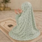 Young girl wearing a soft, breathable kids namaz chadar with comfortable sleeves, ideal for children offering namaz. BY CLOTHIFYDOTPK