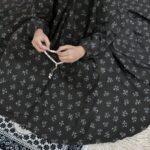 A kid wearing breathable soft swiss lawn modest coverage Namaz Chadar with sleeves, performing salah. By Clothifydotpk