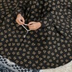 A kid wearing breathable soft swiss lawn modest coverage Namaz Chadar with sleeves, performing salah. By Clothifydotpk