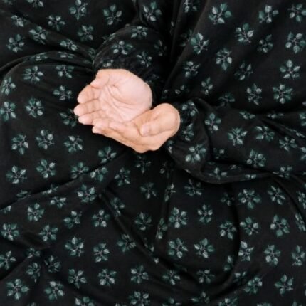 A kid wearing breathable soft swiss lawn modest coverage Namaz Chadar with sleeves, performing salah. By Clothifydotpk
