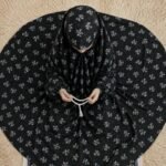 A young girl wearing a soft, lightweight kids namaz chadar with sleeves made of breathable fabric, sized perfectly for a child offering salah. BY CLOTHIFYDOTPK