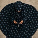 A young girl wearing a soft, lightweight kids namaz chadar with sleeves made of breathable fabric, sized perfectly for a child offering salah. BY CLOTHIFYDOTPK