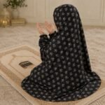 A young girl wearing a soft, lightweight kids namaz chadar with sleeves made of breathable fabric, sized perfectly for a child offering salah. BY CLOTHIFYDOTPK