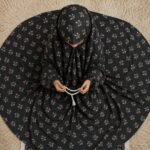 A young girl wearing a soft, lightweight kids namaz chadar with sleeves made of breathable fabric, sized perfectly for a child offering salah. BY CLOTHIFYDOTPK