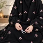 Woman wearing floral embroidered namaz chadar with sleeves for modest Islamic prayerwear. BY CLOTHIFYDOTPK