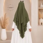 A woman wearing a three layer khimar, with the first layer covering her head and draping down over her chest, and two additional sheer or lightweight layers cascading underneath. BY CLOTHIFYDOTPK