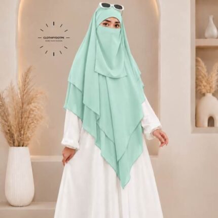 A woman wearing a three layer khimar, with the first layer covering her head and draping down over her chest, and two additional sheer or lightweight layers cascading underneath. BY CLOTHIFYDOTPK