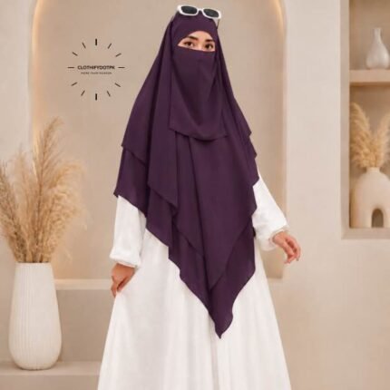 A woman wearing a three layer khimar hijab, with the first layer covering her head and draping down over her chest, and two additional sheer or lightweight layers cascading underneath. BY CLOTHIFYDOTPK