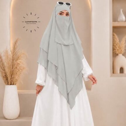 A woman wearing a three layer khimar, with the first layer covering her head and draping down over her chest, and two additional sheer or lightweight layers cascading underneath. BY CLOTHIFYDOTPK